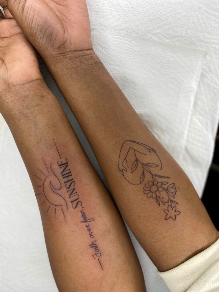 Two fine line forearm tattoos with floral and script designs