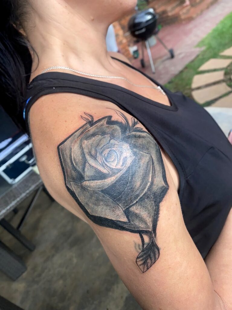 Black rose cover-up tattoo on the upper arm