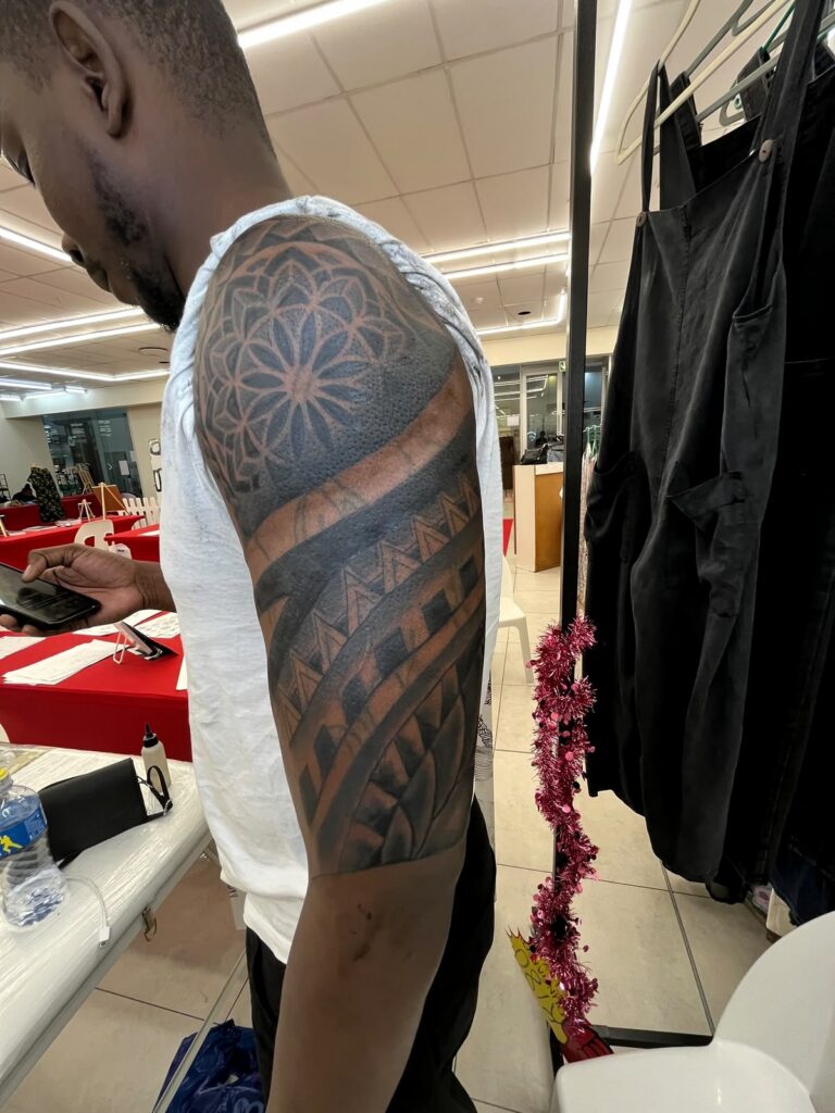 Geometric black and grey upper-arm tattoo