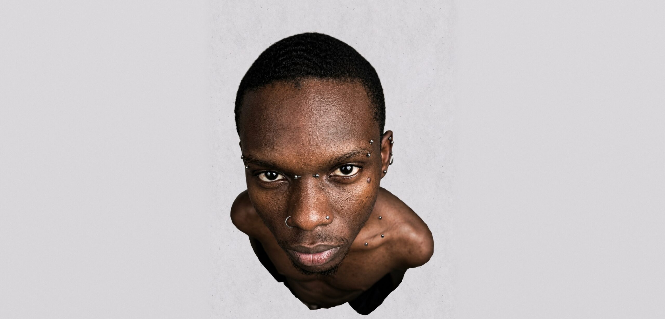 Model with facial piercings in the interactive piercing reveal